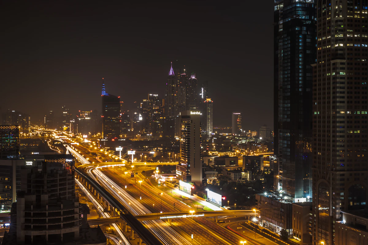 Illuminated highways and long-exposure traffic trails between Dubai towers at night